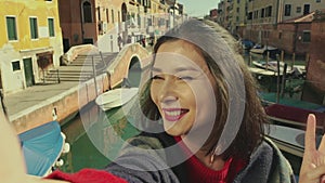 ASian woman in Venice, taking selfie self-portrait photo on vacation travel in Italy. Smiling happy Asian woman outdoors