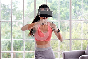 Asian woman virtual reality headset while exercise at home, Healthy asia girl wearing vr glasses for interactive exercise, e sport