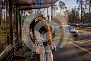 Asian Woman Waiting For Bus At Bus Stop In City Street And Wearing Face Mask Protect In Winter