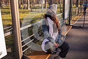 Asian Woman Waiting For Bus At Bus Stop In City Street And Wearing Face Mask Protect In Winter