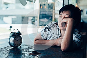 Asian woman waiting in coffee shop cafe with clock