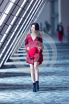Asian woman walking in the street with modern architectural background