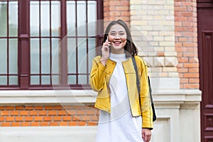 Asian woman walking on the street, wearing cute trendy outfit and talking om her smart phone. City Urban Asian girl talking on her