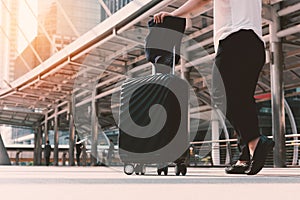 Asian woman walking to airport terminal with luggage. Business t