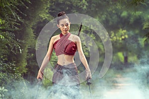 Asian woman warrior in Ayutthaya costume standing in smoke background