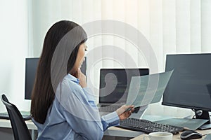 Asian woman was stressed in the early morning while contemplating the programs and codes on the computer screen