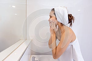 Asian Woman wash her face in the bathroom after shower