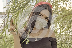 Asian Woman Wear Face Mask Outdoor In The Branches Of Willow photo