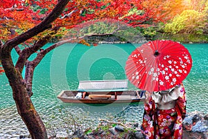 Asian woman wear Kimono and watch The leaves change color. Boatman on the Katsura River on both sides is full of beautiful