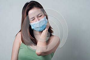 Asian Woman wear a mask are feeling neck pain.