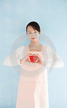 Asian woman wearing an apron to make a heart