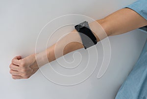 Asian woman wearing black elbow brace to reduce pain