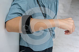 Asian woman wearing black elbow brace to reduce pain