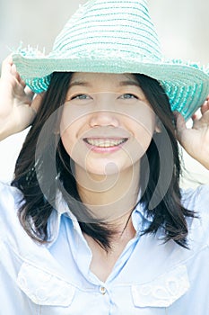 Asian woman wearing a blue hat with smiling face