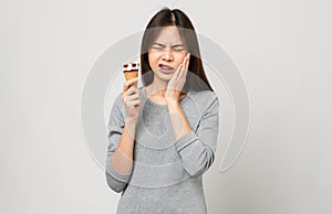 Asian woman wearing braces with sensitive teeth Because eating ice cream that is cold on grey background