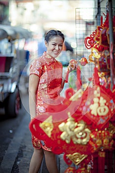 Asian woman wearing chinese tradition clothes with chinese  bamboo fan smiling face in yaowarat street china town of bangkok