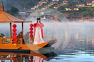 Asian woman wearing chinese traditional dress on Yunan boat at Ban rak thai village in mae hong son province, Thailand