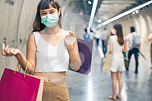 Asian woman wearing face mask. Happy woman with shopping bags enjoying in shopping. Girl holding colour paper bag.Friends walking