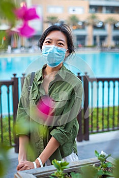 Asian woman wearing face mask in outdoors shopping mall