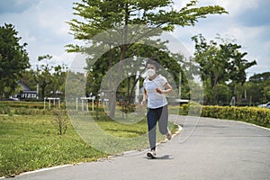 Asian woman wearing face mask while she runningd city lockdown a new normal life.