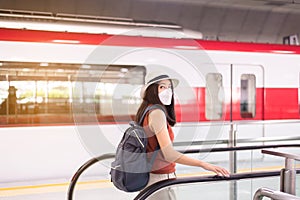 Asian woman wearing face mask and using escalator at train station,Safety on public transport,New normal during covid-19 pandemic