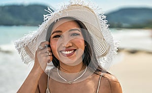 Asian woman wearing fashion summer beach hat for skin care sun protection. Beauty portrait on summer vacation travel