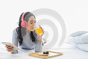 Asian woman wearing headphone in bedroom