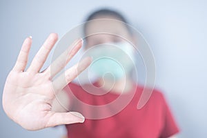 Asian woman wearing a hygiene protective mask to protect COVID-19 and Show hand, don`t come in. Self-isolate or Self-quarantine