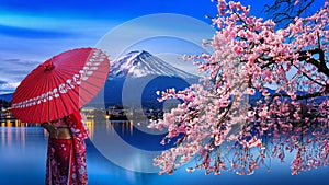 Asian woman wearing japanese traditional kimono at Fuji mountain and cherry blossom, Kawaguchiko lake in Japan photo