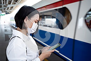 Asian woman wearing a mask waits on a subway train as a COVID-19 outbreak occurs in the country, conception of infection and