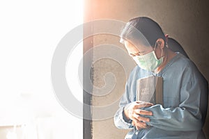 Asian woman wearing medical mask and praying