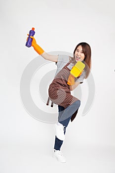 Asian woman wearing orange rubber gloves for hands protection and holding cleaning products and yellow sponge