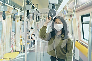 Asian woman wearing protection mask standing in  city sky trains