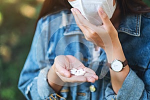 An asian woman wearing protective face mask and holding white medicine capsules in hand for Healthcare and Covid-