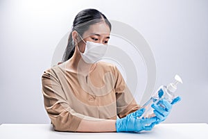 Asian woman wearing protective mask and presenting alcohol antiseptic gel