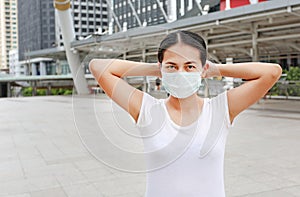 Asian woman wearing protective mask to protect virus, pollution and the flu at public area