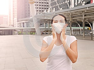 Asian woman wearing protective mask to protect virus, pollution and the flu at public area