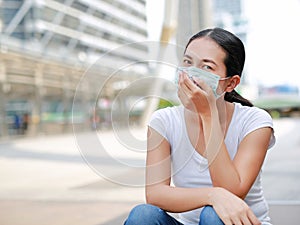 Asian woman wearing protective mask to protect virus, pollution and the flu at public area