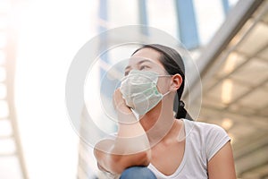 Asian woman wearing protective mask to protect virus, pollution and the flu at public area