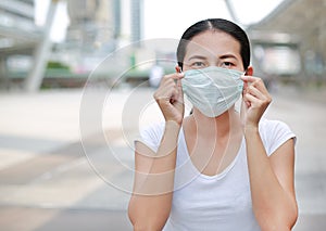 Asian woman wearing protective mask to protect virus, pollution and the flu at public area