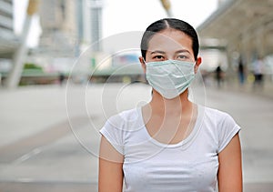 Asian woman wearing protective mask to protect virus, pollution and the flu at public area