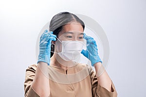 Asian woman is wearing sanitary gloves, mask on her face against coronavirus or COVID-19 disease. The Pollution Healthcare and