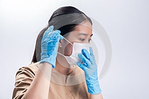 Asian woman is wearing sanitary gloves, mask on her face against coronavirus or COVID-19 disease. The Pollution Healthcare and