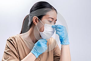 Asian woman is wearing sanitary gloves, mask on her face against coronavirus or COVID-19 disease. The Pollution Healthcare and