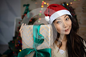 Asian Woman Wearing Santa Claus Hat And Holding Gift Boxes. Christmas New Year Concept