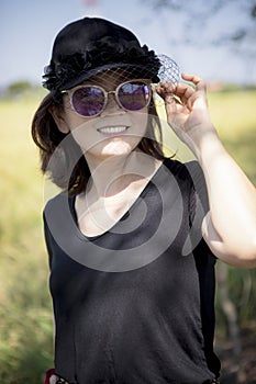 Asian woman wearing sun glasses toothy smiling face happiness emotion standing outdoor