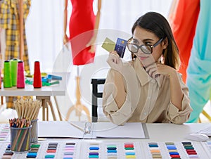 Asian woman wearing Sunglasses tailor with showing credit card is Business Working women at their store. Entrepreneurial success.