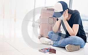 Asian woman wearing surgical mask feeling sad and depress for missed or cancelled flight for aboard to other place at the airport