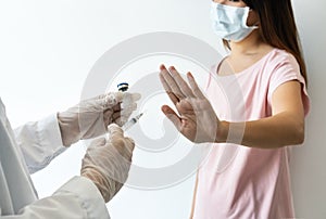 Asian woman wearing surgical mask refuse nurse injection or vaccination. Rejection of the vaccine, insecurity and fear concept photo