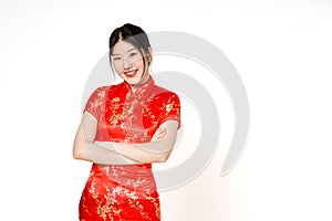Asian woman wearing traditional cheongsam qipao dress with gesture standing and looking forward with arms crossed on white